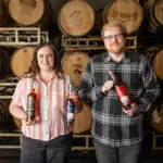 Adam and Nora holding 250th bottles